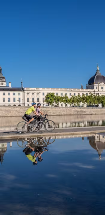 Cyclists passing in front of the Grand Hôtel-Dieu in Lyon