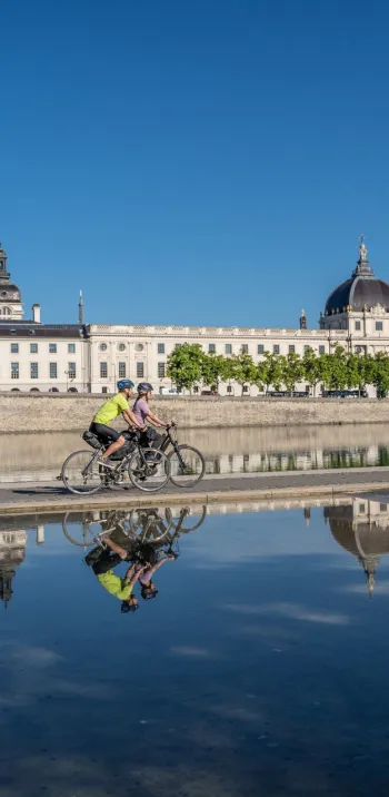 Cyclists passing in front of the Grand Hôtel-Dieu in Lyon