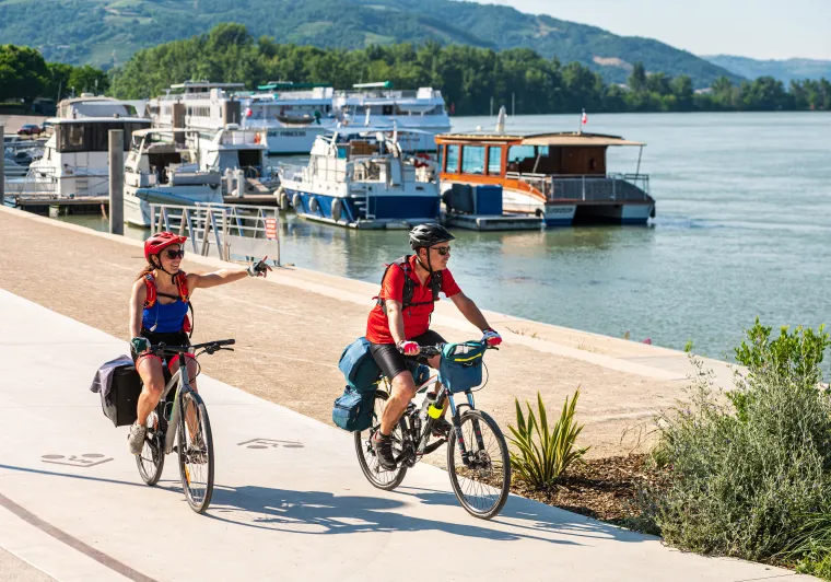 Couple cycling along the quays of Tournon sur Rhône (Ardèche)
