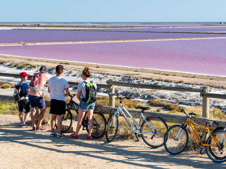 Cyclistes devant les marrais salants aux Saintes-Maries-de-la-Mer